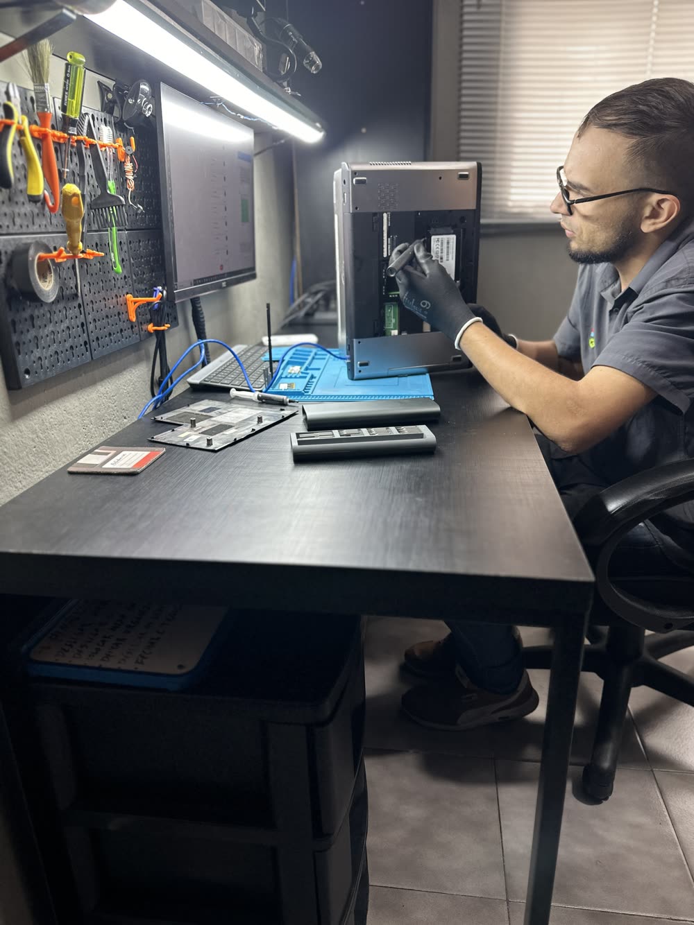 Técnico da Provider consertando um notebook no laboratório